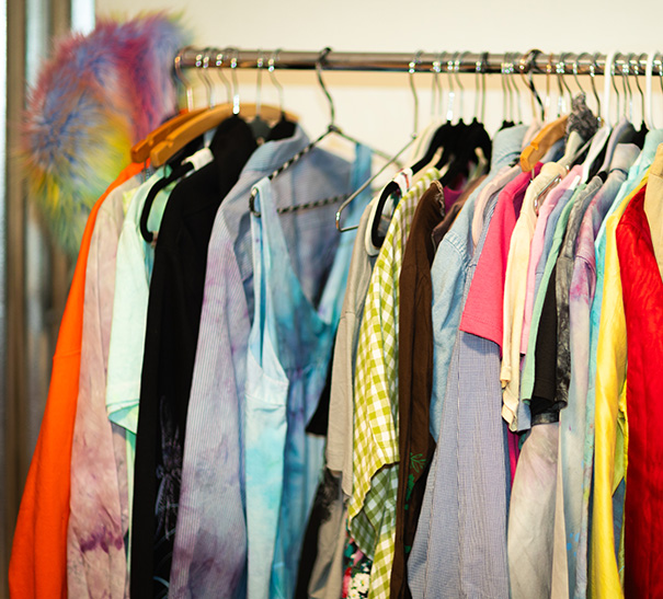 A clothes-rack filled with unique custom-printed pieces of clothing.